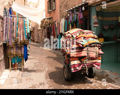 Eine enge Straße in den Souks der alten Medina mit marokkanischen Teppichen und farbenfrohen Teppichen mit traditionellen Mustern in Marrakesch, Marokko, Afrika Stockfoto