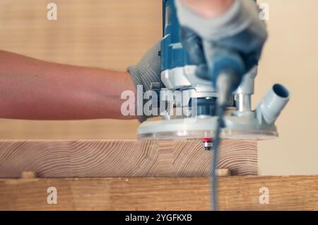 Glätten der Kanten eines Holzbretts mit einem Handfräser, Nahaufnahme der feinen Handwerkskunst Stockfoto