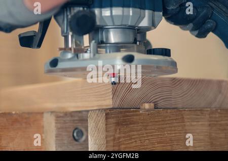 Nahaufnahme eines Handfräsers zum Glätten von Holzbrettkanten, Präzisionsholzbearbeitung in Aktion Stockfoto