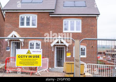 Baustelle der Vistry Group. CCTV-Schild auf einem Stahlzaun vor den im Bau befindlichen Häusern in Midlands, Großbritannien. Stockfoto