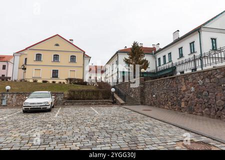 Minsk, Weißrussland - 3. Januar 2024: Blick auf die Dreifaltigkeitsvorstadt mit einem Auto, das an einem bewölkten Wintertag vor alten Wohnhäusern parkt Stockfoto