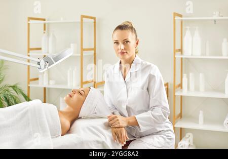 Porträt einer jungen Kosmetikerin, die mit Kunden im Schönheitssalon arbeitet Stockfoto