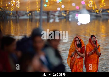 Kathmandu, Nepal. November 2024. Hindufrauen stehen am Ufer des Flusses, um während des Chhath-Festivals der untergehenden Sonne zu beten. Auf Chhath, einem alten fest, das von Hindus beobachtet wurde, versammeln sich die Gläubigen am heiligen Fluss, um Gebete durch Fasten, Baden und Stehen im Wasser für ununterbrochene Zeiträume zu opfern, um dem Sonnengott zu beten, und danken und Respekt zu erweisen, um Segnungen für das Leben auf Erden zu suchen. Quelle: SOPA Images Limited/Alamy Live News Stockfoto