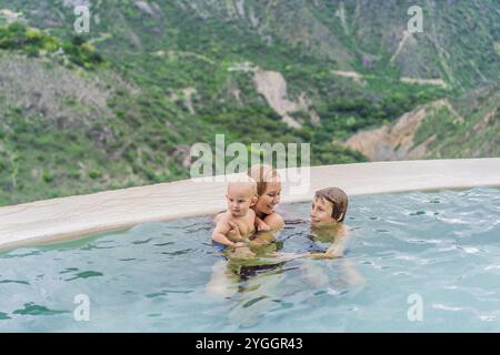 Mutter mit ihrem Kleinkind und ihren Söhnen im Teenageralter baden in den heißen Quellen von Grutas Tolantongo, Mexiko. Familienabenteuer, Entspannung und natürliches Wellness Stockfoto