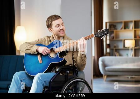 Ein hübscher Mann mit einer Behinderung, der im Rollstuhl sitzt und zu Hause Gitarre spielt. Stockfoto