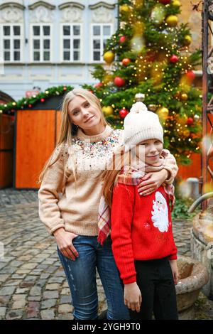 Frau und kleines Mädchen auf dem Weihnachtsmarkt in Prag. Mutter und Tochter zusammen im Freien genießen saisonale Winterferien Stockfoto