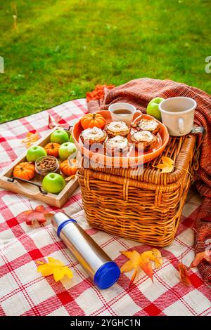 Herbstpicknick in einem Park mit Kürbis-Cupcakes und Muffins, Kaffee und Tee Stockfoto