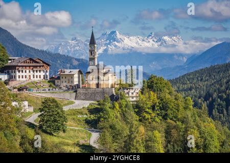 Die kleine Stadt Cibiana di Cadore, Blick mit der Pfarrkirche und im Hintergrund einige Gipfel der südlichen Karnischen Alpen, Cadore, Provinz Bel Stockfoto