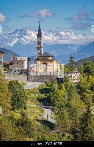 Die kleine Stadt Cibiana di Cadore, Blick mit der Pfarrkirche und im Hintergrund einige Gipfel der südlichen Karnischen Alpen, Cadore, Provinz Bel Stockfoto