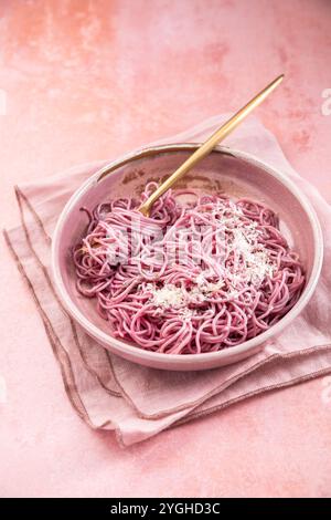 Hausgemachte rosa Nudeln mit Knoblauch, Zitrone und Parmesan, natürlich gefärbt durch Rotkohl Stockfoto