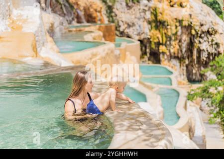 Mutter mit ihrem kleinen Sohn, der in den heißen Quellen von Grutas Tolantongo, Mexiko, baden. Familienabenteuer, Entspannung und natürliches Wellness-Konzept Stockfoto