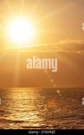 Goldener Sonnenuntergang über Meereswellen, Sonnenstrahlen und Flare, einfacher Hintergrund, Ballito Bay, Durban Stockfoto