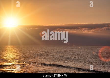 Goldener Sonnenuntergang über Meereswellen, Sonnenstrahlen und Flare, einfacher Hintergrund, Ballito Bay, Durban Stockfoto