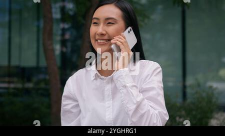 Begeistert Asiatisch Koreanisch Frau Geschäftsfrau Talk Handy Smartphone genießen Lächeln gewinnen Erfolg Manager erreichen Anruf Karriere Vereinbarung Geschäftsfrau Stockfoto