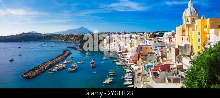 Italien Reisen und Sehenswürdigkeiten. Die malerischste und farbenfrohe Insel - wunderschöne Procida im Golf von Neapel. Panoramablick auf den Hafen von Corricella mit gelbem Churc Stockfoto