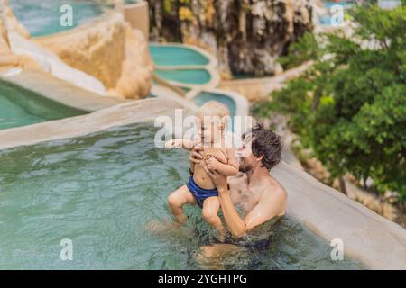 Vater mit seinem Sohn, der in den heißen Quellen von Grutas Tolantongo, Mexiko, baden. Familienabenteuer, Entspannung und natürliches Wellness-Konzept Stockfoto