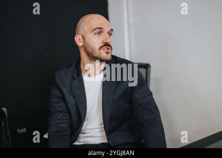 Mann in Geschäftskleidung, der nachdenklich von der Kamera wegschaut Stockfoto