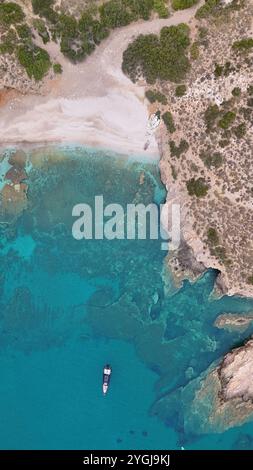 Blick aus der Vogelperspektive auf die abgeschiedene mediterrane Bucht mit kristallklarem türkisfarbenem Wasser, felsiger Küste und einsamem Boot, das in unberührter Bucht vor Anker liegt Stockfoto