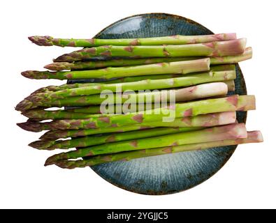 Teller frischer roher grüner Spargel mit Messer auf dem Tisch Stockfoto