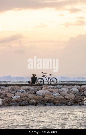 Wasserlandschaft, sanft abfallender Sandstrand mit sanften Wellen. Der nasse Sand reflektiert den unglaublichen Himmel im romantischen Sonnenuntergang in kutan, Bali, Indonesien Stockfoto