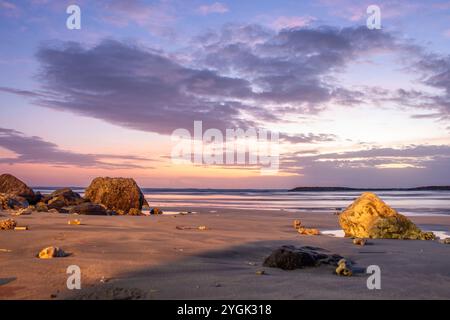 Wasserlandschaft, sanft abfallender Sandstrand mit sanften Wellen. Der nasse Sand reflektiert den unglaublichen Himmel im romantischen Sonnenuntergang in kutan, Bali, Indonesien Stockfoto