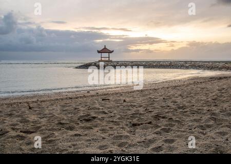 Wasserlandschaft, sanft abfallender Sandstrand mit sanften Wellen. Der nasse Sand reflektiert den unglaublichen Himmel im romantischen Sonnenuntergang in kutan, Bali, Indonesien Stockfoto