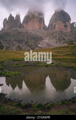 Blick auf die berühmten drei Zinnen in den Sexten Dolomiten in Südtirol. Die Felsformation spiegelt sich im Wasser eines Sees wider. Stockfoto