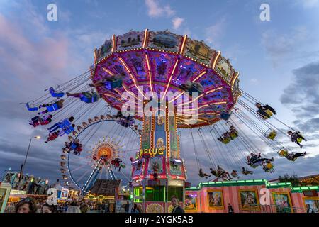 Kettenkarussell auf dem Oktoberfest 2024 in der Abenddämmerung, München, Bayern, Deutschland Stockfoto