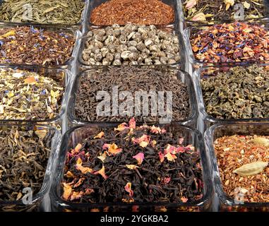 Eine lebhafte Auswahl an Tees mit losen Blättern in Glasgläsern mit grünen, schwarzen, Oolong- und Kräutermischungen. Reich an Farbe und Aroma. Stockfoto