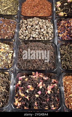 Eine lebhafte Auswahl an Tees mit losen Blättern in Glasgläsern mit grünen, schwarzen, Oolong- und Kräutermischungen. Reich an Farbe und Aroma. Stockfoto