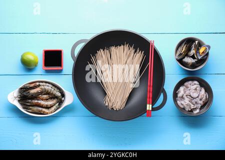 Verschiedene Zutaten für Wok auf hellblauem Holztisch, flach gelegt Stockfoto