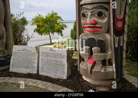 Nahaufnahme des Haida-Totem-Pols und der interpretierenden Marker, die die beiden Pole im Totem-Pole-Park beschreiben. Stockfoto