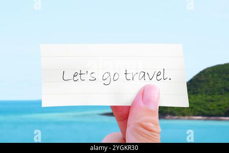 Let's Go Travel Message, handgeschriebenes Reisezitat auf Papier mit der tropischen Insel und dem blauen Himmel Hintergrund, Reise- und Tourismuskonzept Stockfoto