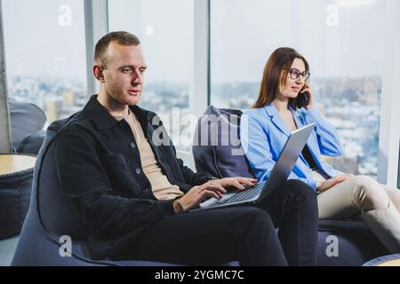 Zwei Geschäftsleute, die per Fernzugriff online mit einem Laptop arbeiten. Kollegen arbeiten Remote am Arbeitsplatz. Stockfoto