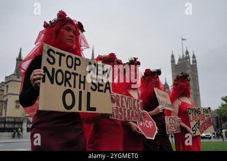 London, England, Großbritannien. November 2024. Fossil Free London Aktivisten inszenieren einen Sterbefall vor den Houses of Parliament, um gegen die Zustimmung der Regierung zum Ölfeld Rosebank zu protestieren. Die Demonstration fordert einen sofortigen Stopp des Projekts, was nach Ansicht von Aktivisten die Klimaverpflichtungen Großbritanniens untergräbt. Die Entscheidung wird von Uplift und Greenpeace gerichtlich angefochten, das Gerichtsverfahren beginnt am 12. November. Der Protest hebt den wachsenden öffentlichen Widerstand gegen die Entwicklung neuer fossiler Brennstoffe hervor. (Kreditbild: © Joao Daniel Pereira/ZUMA Press Wire) NUR REDAKTIONELLE VERWENDUNG! N Stockfoto