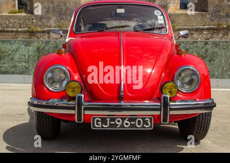 Klassischer roter volkswagen-Käfer, der in gibraltar geparkt ist, zeigt sein kultiges Design und seine leuchtenden Farben Stockfoto