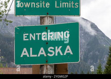 In Hyder City passiert das Schild Alaska, das die internationale Grenze zu Kanada in Stewart, Tongass National Forest, Alaska, USA, passiert. Stockfoto