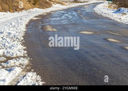 Schneebedeckte Straße, die Spuren der Räder. Stockfoto