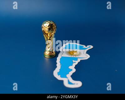 Perak, Malaysia-23. August 2024: Nahaufnahme argentiniens Flaggenaufkleber mit Weltcup-Trophäe auf blauem Hintergrund. Stockfoto