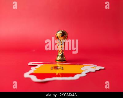 Perak, Malaysia-23. August 2024: Nahaufnahme-WM-Trophäe mit spanischen Flaggenaufklebern auf rotem Hintergrund. Stockfoto