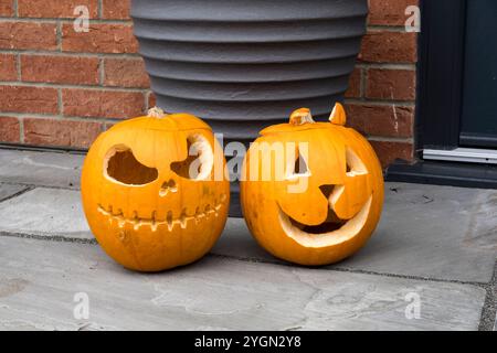 Zwei Halloween-Kürbisköpfe vor der Haustür Stockfoto