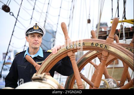 Hamburg, Deutschland. November 2024. Elmar Bornkessel, Kommandant der Gorch Fock, hält das Lenkrad an Bord des Schiffes. Das Ausbildungssegelschiff „Gorch Fock“ wird am 9. Und 10. November 2024 in Hamburg für Besucher geöffnet. Quelle: Niklas Graeber/dpa/Alamy Live News Stockfoto