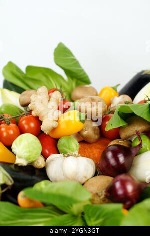 Vertikales Bild von frischem, natürlichem Mischgemüse. Enthält Pac Choi, rote Zwiebeln, Knoblauch, Rosenkohl, Tomaten, Paprika, Pilze, Ingwer, c Stockfoto