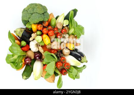 Rohes gemischtes Bio-Gemüse, fotografiert von oben, auf weißem Hintergrund. Einschließlich Brokkoli, Pac Choi, rote Zwiebeln, Knoblauch, Rosenkohl, Tomaten Stockfoto