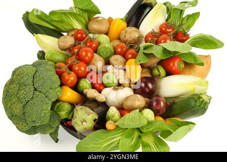 Rohes gemischtes Bio-Gemüse, fotografiert aus einem höheren Winkel oben, auf weißem Hintergrund. Enthält Brokkoli, Pac Choi, rote Zwiebeln, Knoblauch, Brüssels Stockfoto