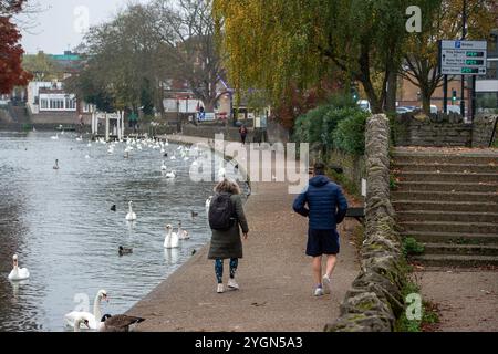 Windsor, Berkshire, Großbritannien. November 2024. Die Leute laufen an der Themse entlang. Es war ein weiterer langweiliger, aber milder Morgen in Windsor, Berkshire. Eine antizyklische Dunkelheit in ganz England setzt sich fort. Quelle: Maureen McLean/Alamy Live News Stockfoto