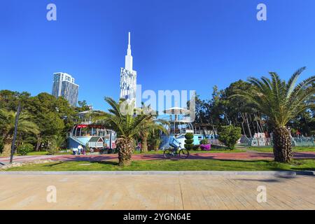 Batumi, Georgia, 30. April 2017: Menschen, die im Park mit Palmen in der Nähe der Promenade Boulevard des georgianischen Sommerresorts in Asien spazieren Stockfoto