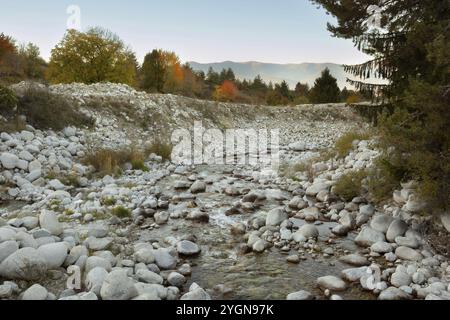 Bansko, Bulgarien Herbstlandschaft mit Fluss Glazne, bunten Bäumen und Rila-Gipfeln bei Sonnenuntergang Stockfoto