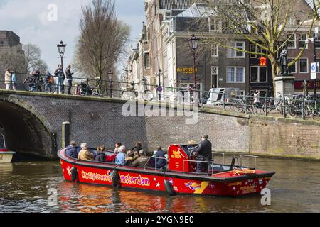 Amsterdam, Niederlande, 2. April 2016: Traditionelle alte Gebäude, Kanal und Boot mit Touristen in Amsterdam, Niederlande Stockfoto