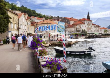 Perast, Montenegro, 21. September 2023: Panoramablick auf die historische Stadt an der berühmten Bucht von Kotor mit Booten im Sommer und Rahmen für Fotos auf Promena Stockfoto